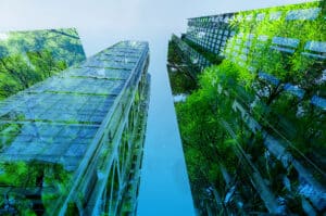 skyscrapers overgrown with green trees as metaphor for the ESG transformation advancing